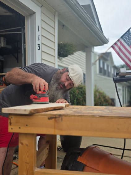 Nathan sanding a live-edge hardwood piece in the Honor & Oak workshop